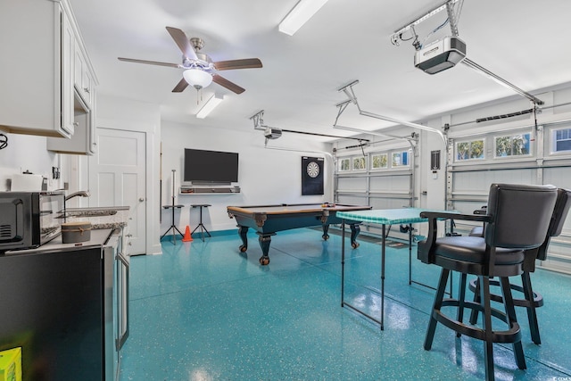 rec room with a ceiling fan, speckled floor, a garage, and a sink