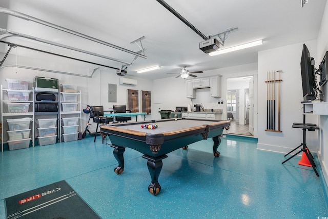 rec room featuring a wall unit AC, speckled floor, baseboards, electric panel, and a garage