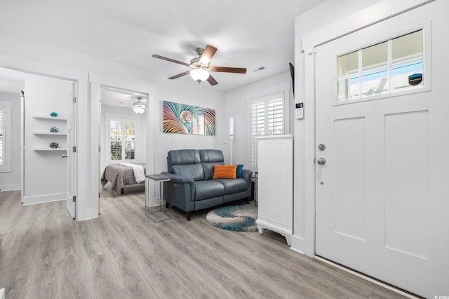 foyer with a ceiling fan, visible vents, and light wood-type flooring