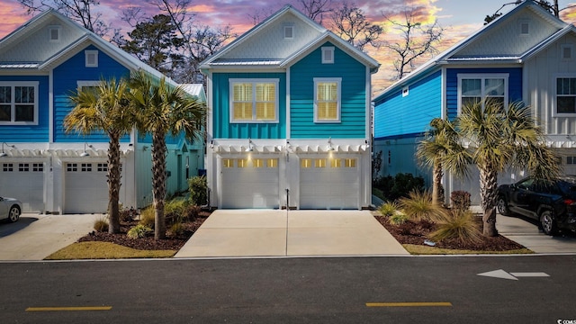 coastal inspired home featuring board and batten siding, concrete driveway, and a garage