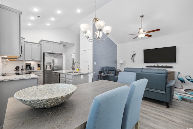 dining space featuring visible vents, high vaulted ceiling, light wood-style flooring, recessed lighting, and ceiling fan with notable chandelier