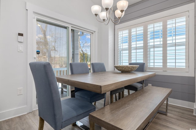 dining room with a wealth of natural light, baseboards, a chandelier, and light wood finished floors