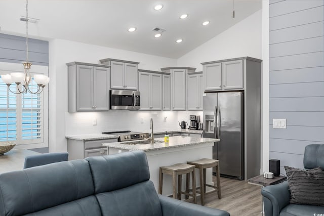 2406 Seabreeze Pl, Myrtle Beach, SC 29577 - kitchen with stainless steel appliances, open floor plan, gray cabinetry, light wood finished floors, and vaulted ceiling