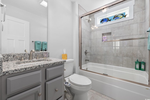 full bath featuring tile patterned floors, combined bath / shower with glass door, toilet, and vanity