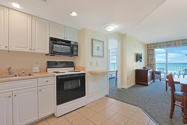 2501 S Ocean Blvd Unit 201, Myrtle Beach, SC 29577 - kitchen featuring electric stove, black microwave, light colored carpet, a sink, and white cabinets