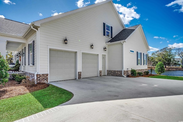 view of home's exterior featuring a garage, concrete driveway, and a shingled roof