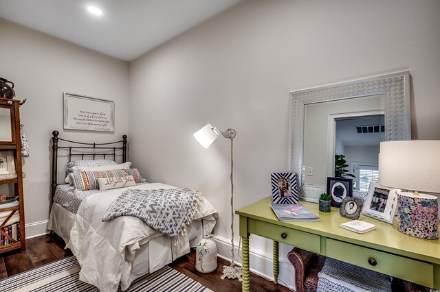 bedroom with visible vents, baseboards, and wood finished floors