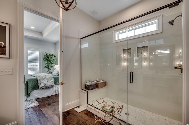 ensuite bathroom with a stall shower, connected bathroom, visible vents, and wood finished floors