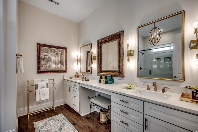 full bath featuring double vanity, a stall shower, wood finished floors, and a sink