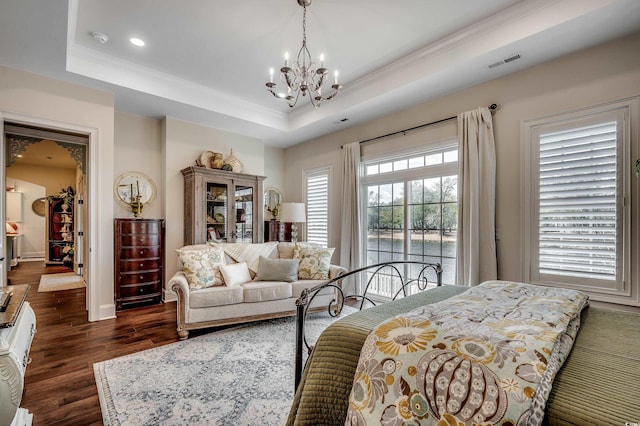 bedroom with visible vents, crown molding, an inviting chandelier, dark wood-style floors, and a raised ceiling