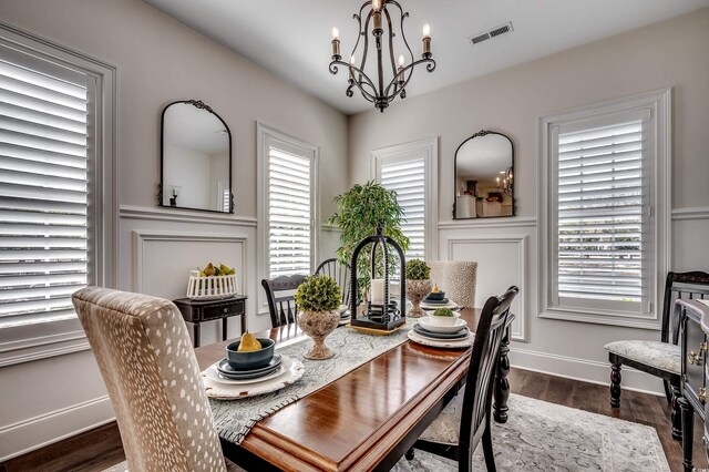 dining space featuring visible vents, dark wood-style floors, and a chandelier