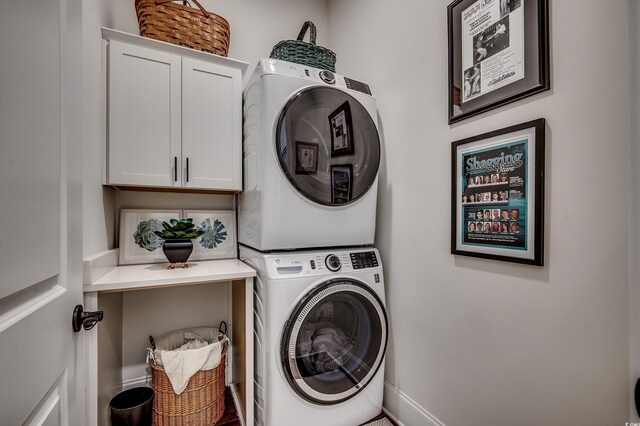 washroom with cabinet space and stacked washer and dryer