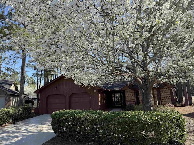 view of front facade featuring an attached garage, brick siding, and driveway