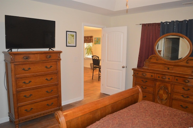 bedroom with wood finished floors, visible vents, and baseboards
