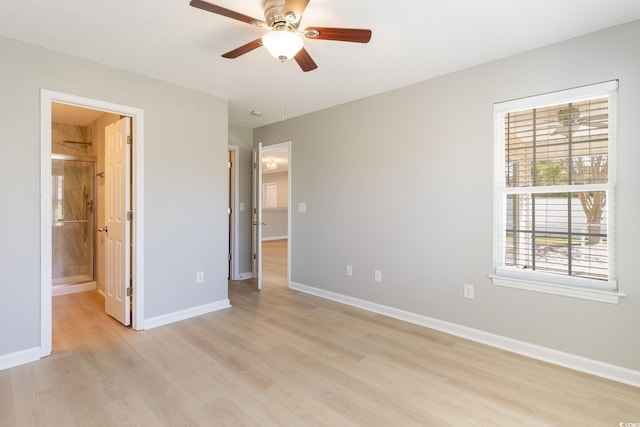 unfurnished bedroom with light wood-style flooring, baseboards, and connected bathroom