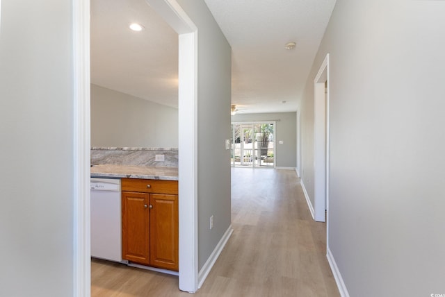 hallway with recessed lighting, light wood-type flooring, and baseboards