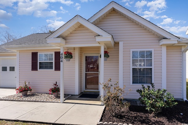 bungalow-style home with roof with shingles and an attached garage