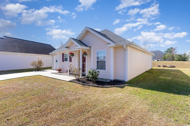 bungalow-style house featuring a shingled roof and a front yard