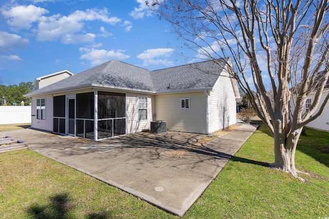 back of property with a patio, a sunroom, fence, a yard, and a shingled roof