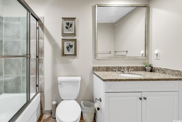 full bath with vanity, toilet, and combined bath / shower with glass door