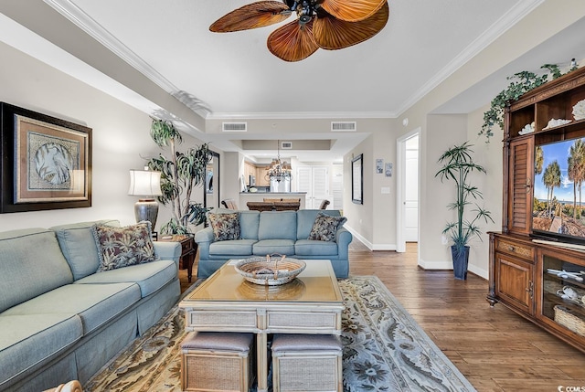 living area featuring visible vents, baseboards, dark wood-style flooring, and crown molding