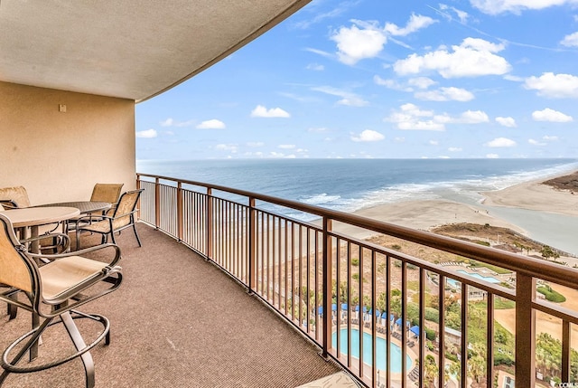 balcony featuring a view of the beach and a water view