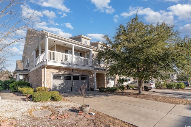 view of front of house with brick siding, a balcony, concrete driveway, and an attached garage