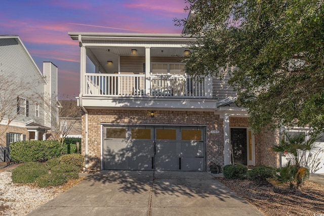 view of front of house with a garage, brick siding, and concrete driveway