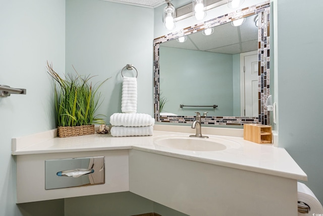 bathroom with vanity, a paneled ceiling, and tasteful backsplash