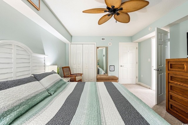 carpeted bedroom with baseboards, visible vents, a closet, and ceiling fan