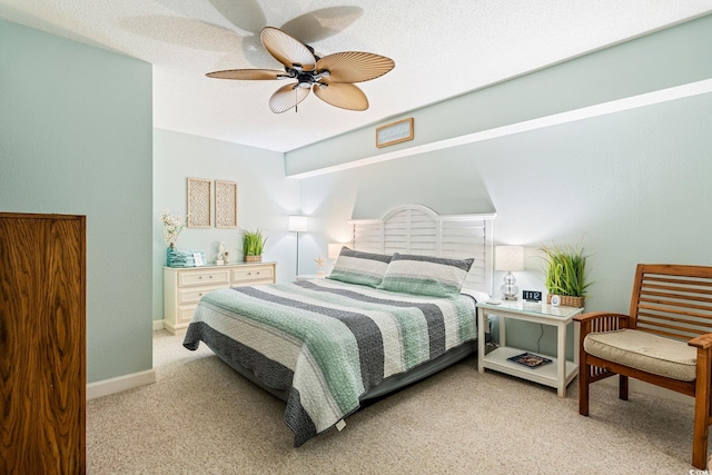 carpeted bedroom with ceiling fan, baseboards, and a textured ceiling