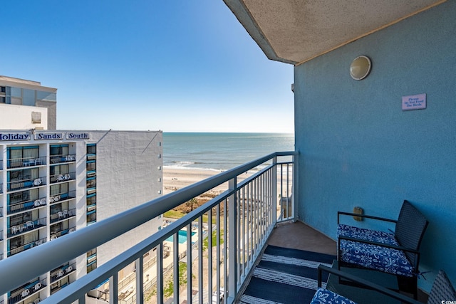 balcony featuring a view of the beach and a water view