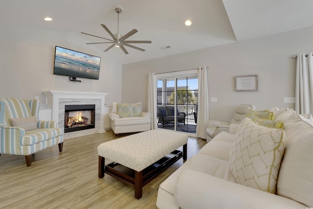 living room featuring light wood finished floors, visible vents, lofted ceiling, recessed lighting, and a fireplace