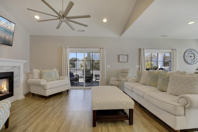 living room with wood finished floors, visible vents, recessed lighting, a fireplace, and vaulted ceiling