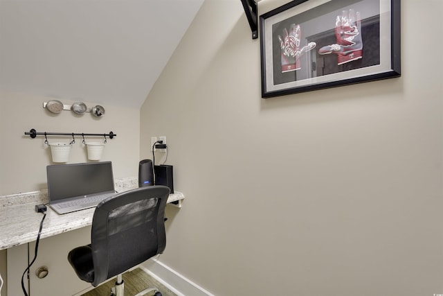 office space featuring baseboards, lofted ceiling, and wood finished floors