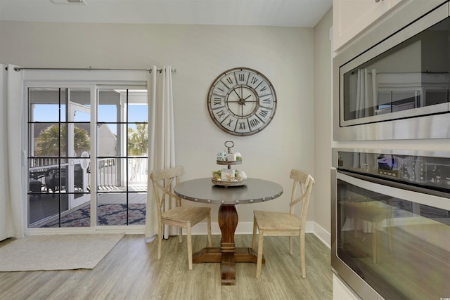 dining area with visible vents, baseboards, and light wood-style floors