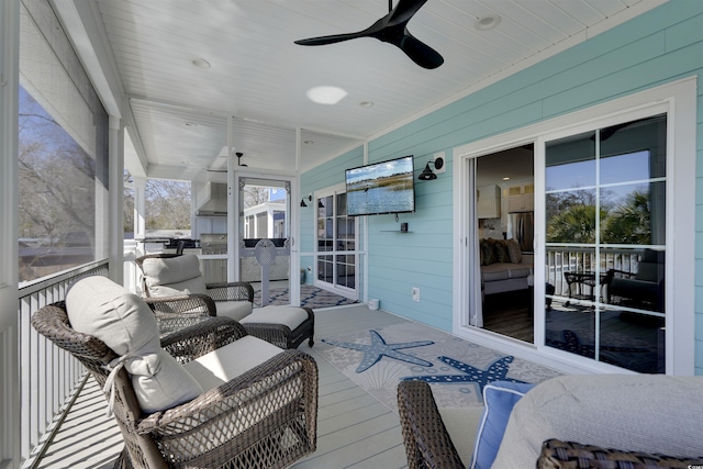 sunroom / solarium featuring a ceiling fan