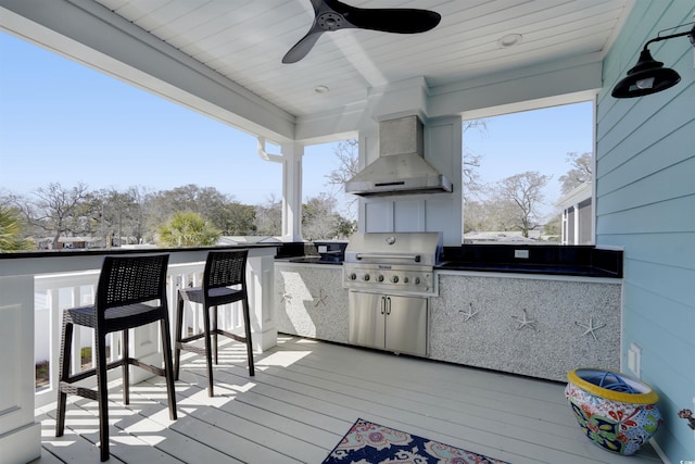 wooden deck with grilling area, an outdoor kitchen, outdoor wet bar, and ceiling fan