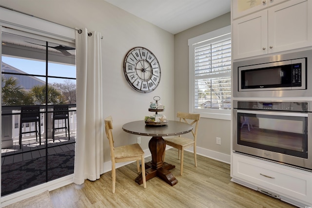 dining area with baseboards, plenty of natural light, and light wood finished floors