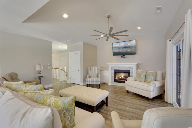 living area featuring a high end fireplace, recessed lighting, and wood finished floors