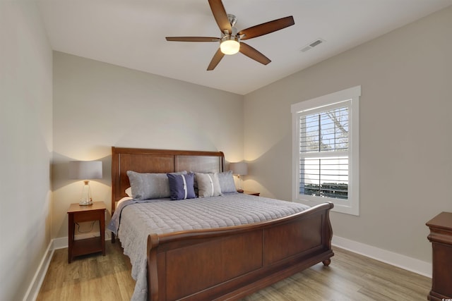 bedroom with light wood-type flooring, visible vents, and baseboards