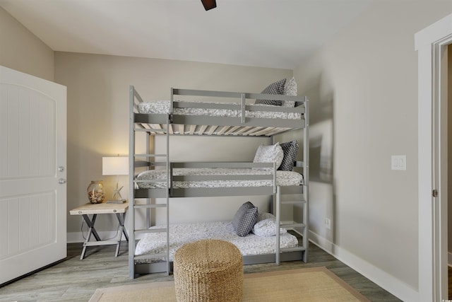 bedroom featuring wood finished floors, baseboards, and ceiling fan