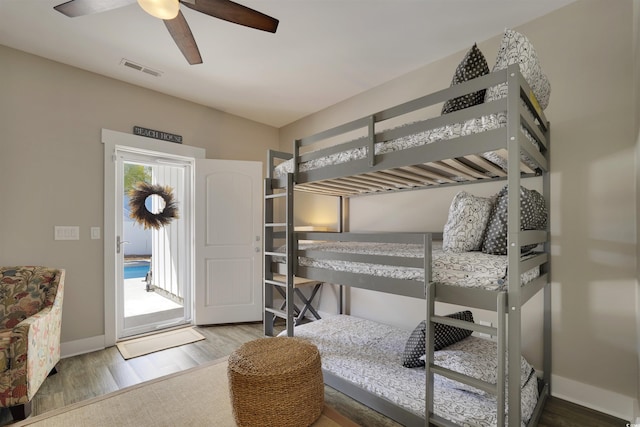 bedroom featuring visible vents, baseboards, wood finished floors, and access to outside