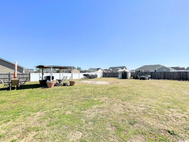 view of yard featuring an outbuilding, a shed, and a fenced backyard