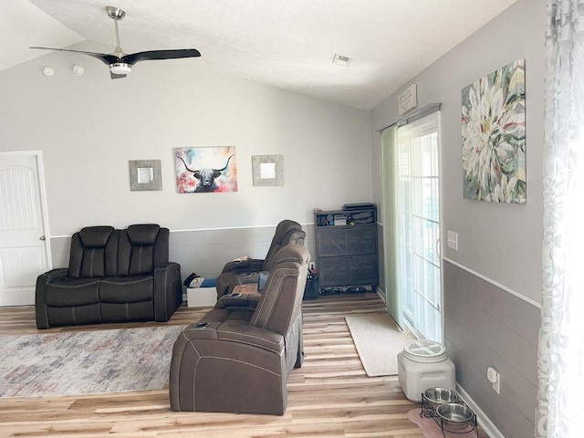 living room featuring a ceiling fan, lofted ceiling, and wood finished floors