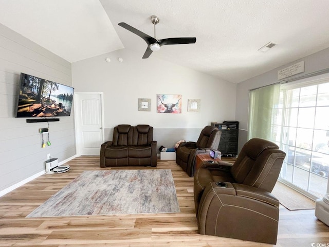 living room featuring visible vents, wood finished floors, a ceiling fan, and vaulted ceiling