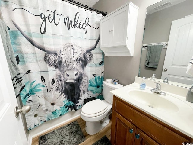 bathroom featuring curtained shower, toilet, vanity, and visible vents