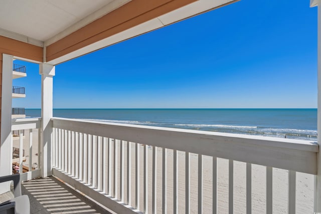 balcony featuring a water view and a beach view