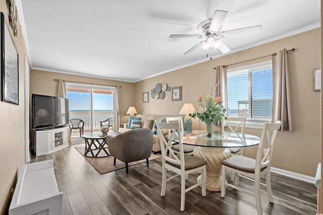 dining room with crown molding, wood finished floors, baseboards, and ceiling fan