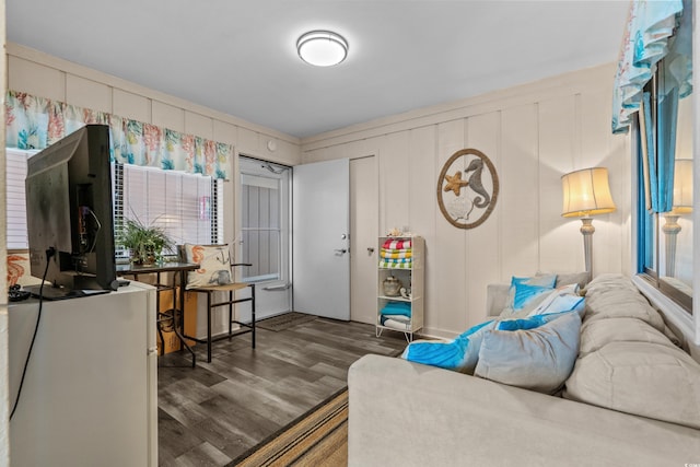 living area featuring a decorative wall and wood finished floors